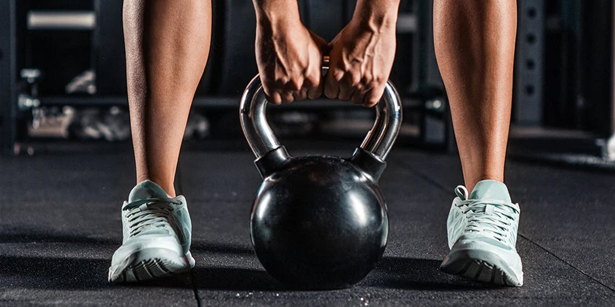 Female grasping a kettlebell with two hands